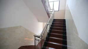 Una escalera con barandilla de metal y escalones de madera.
