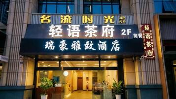 A hotel entrance with signage indicating it is a 2F building, possibly a restaurant or cafe, with a modern facade and entrance doors.