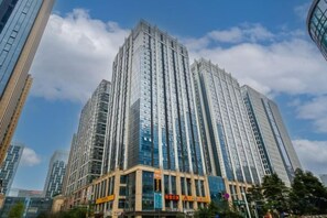 A high-rise building with a modern glass facade and a prominent entrance with signage. - Ruihao Yazhi Hotel (Global Center Store) (Chengdu)