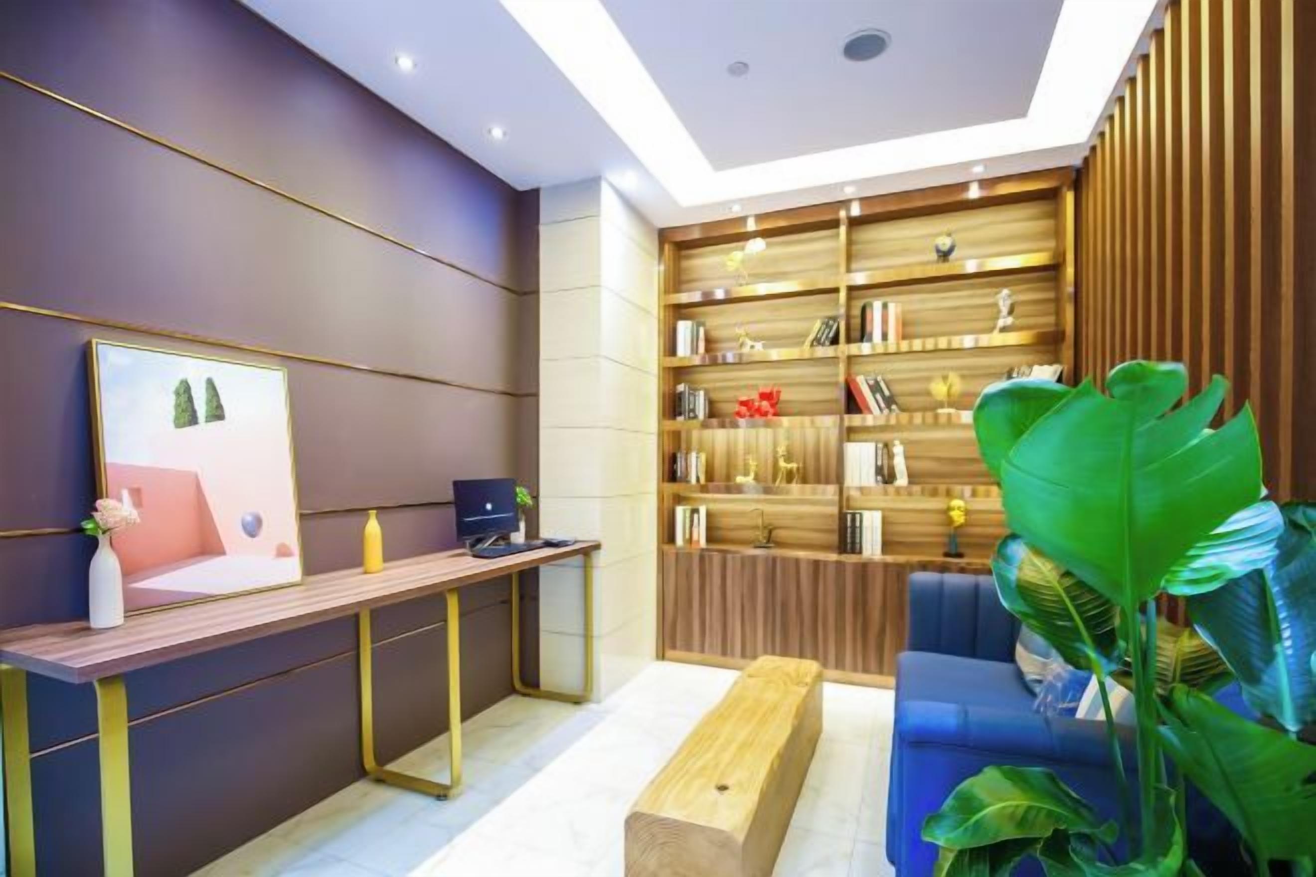 A modern interior with a wooden desk, a blue sofa, and a bookshelf.