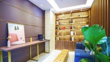 A modern interior with a wooden desk, a blue sofa, and a bookshelf.