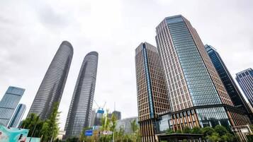 Un moderno horizonte urbano con rascacielos, cielo despejado y una calle con poco tráfico.