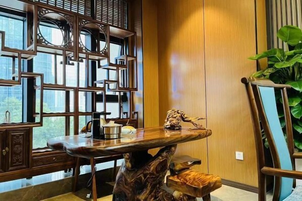 A modern interior with a wooden table, a decorative wall, and a plant. - Ruihao Yazhi Hotel (Global Center Store) (Chengdu)