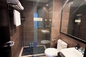 Uma casa de banho moderna com chuveiro envidraçado, sanita e lavatório.
