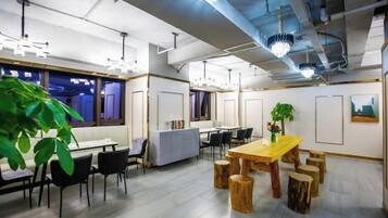A modern office space with a long table, several chairs, and a potted plant.
