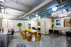 Una sala conferenze moderna con un tavolo di legno, sedie e una pianta grande.