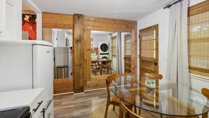 A compact kitchen with modern appliances, a dining area with a glass table, and wooden accents. - Escape to Nashville: 15 min to Downtown & BNA, sleeps 4, gated parking! (Madison)
