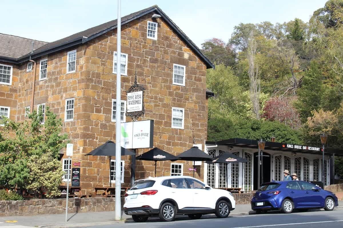 A stone building with a sign for 'Kings Bridge Bar & Restaurant' and a sign for 'Benny's Rosewater Watermill.'