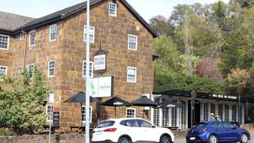 A stone building with a sign for 'Kings Bridge Bar & Restaurant' and a sign for 'Benny's Rosewater Watermill.'
