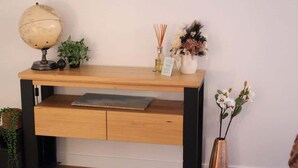 A wooden desk with a globe, plants, and a vase.