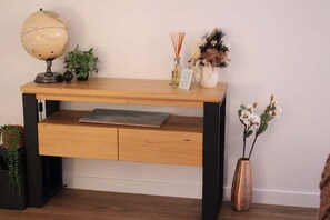 A wooden desk with a globe, plants, and a vase.