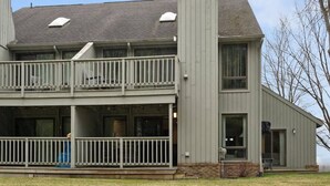 A two-story house with a balcony, a covered porch, and a garage. - GT Resort Area I Fireplace + Golf Views (Williamsburg)