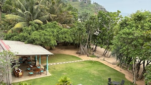 A swimming pool with lounge chairs, a covered seating area, and a view of the surrounding greenery and hills. - Villa Talay (Talalla)