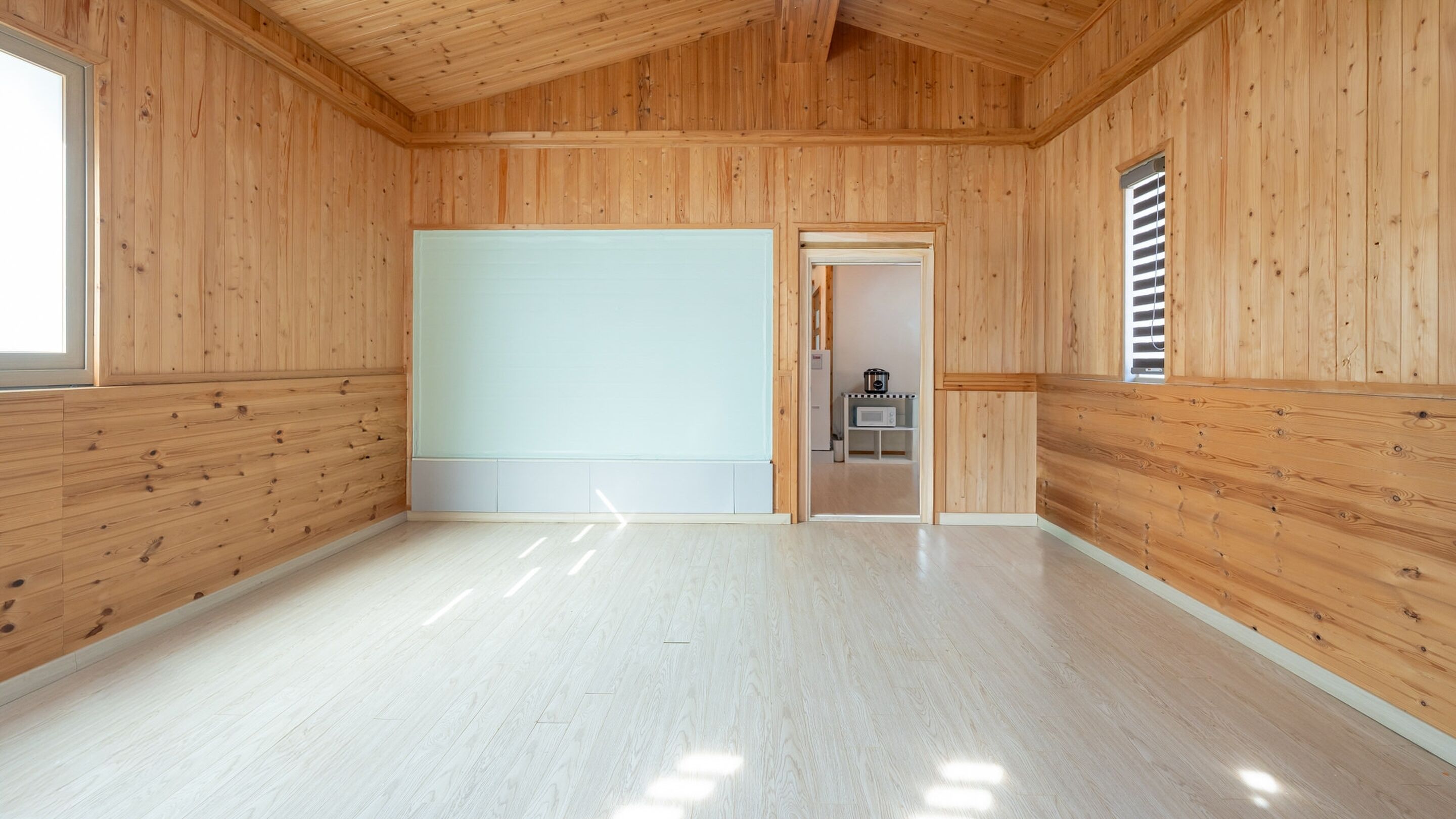 A room with wooden walls and a light-colored floor.