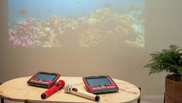 A table with two electronic devices, a red and a white one, and a microphone.