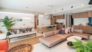 Una sala de estar moderna con un sofá, una mesa de centro y una zona de comedor con un banco.