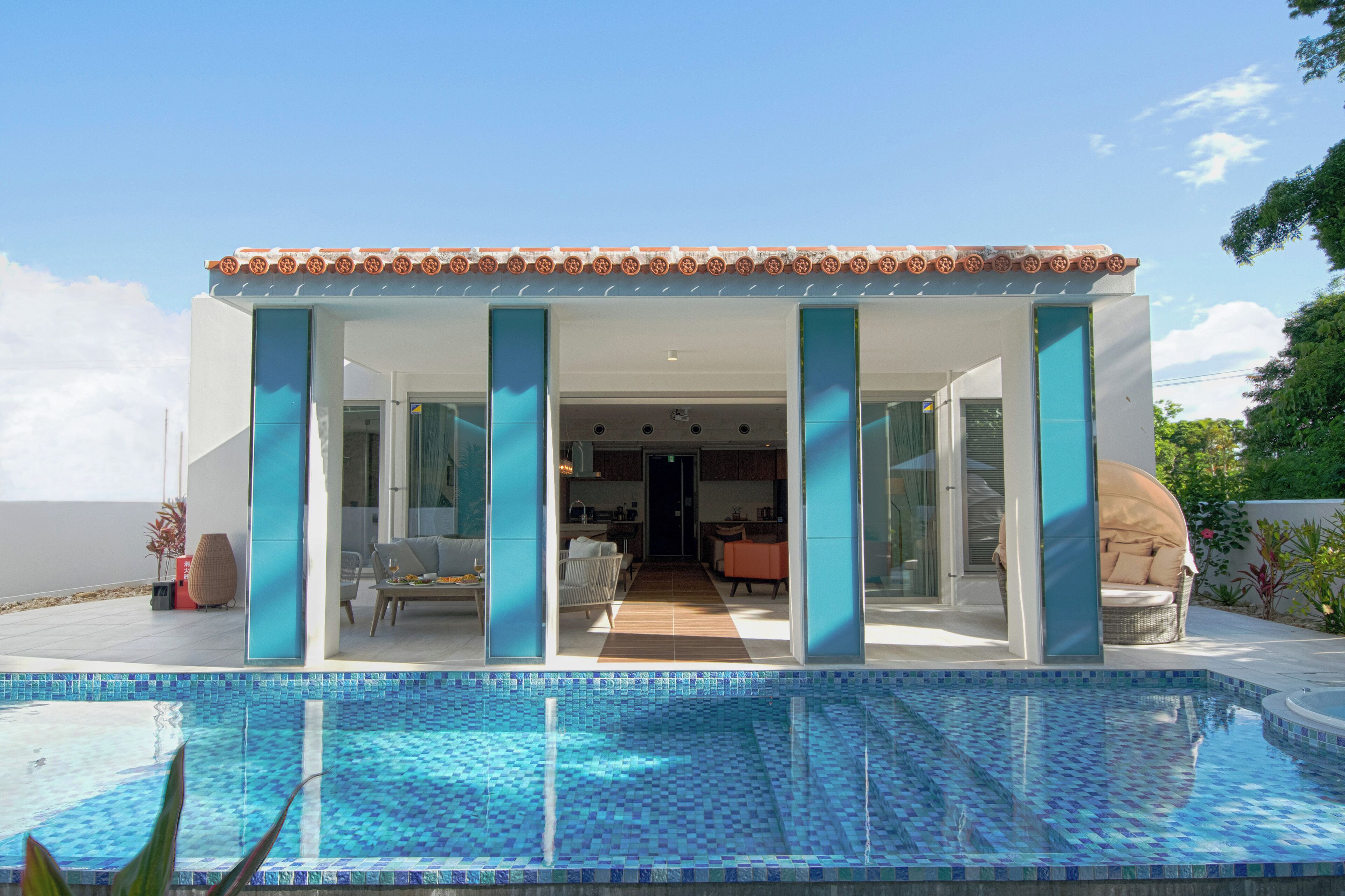 Una casa moderna con piscina, que cuenta con un patio amoblado y vistas al interior.
