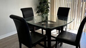 A conference room with a glass table, four black chairs, and a potted plant. - Cozy Whitby Retreat (Private 2 Bedroom Townhouse) (Whitby)