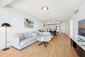 Ein modernes Wohnzimmer mit Sofa, Couchtisch und Stehlampe.