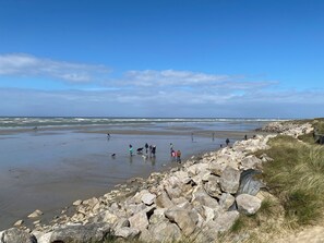 A beach with rocky terrain and a clear sky.