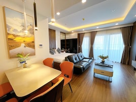 Et moderne hotelværelse med spiseplads, sofa og seng.
