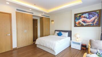 A modern bedroom with a large bed, wooden wardrobe, and a painting on the wall.