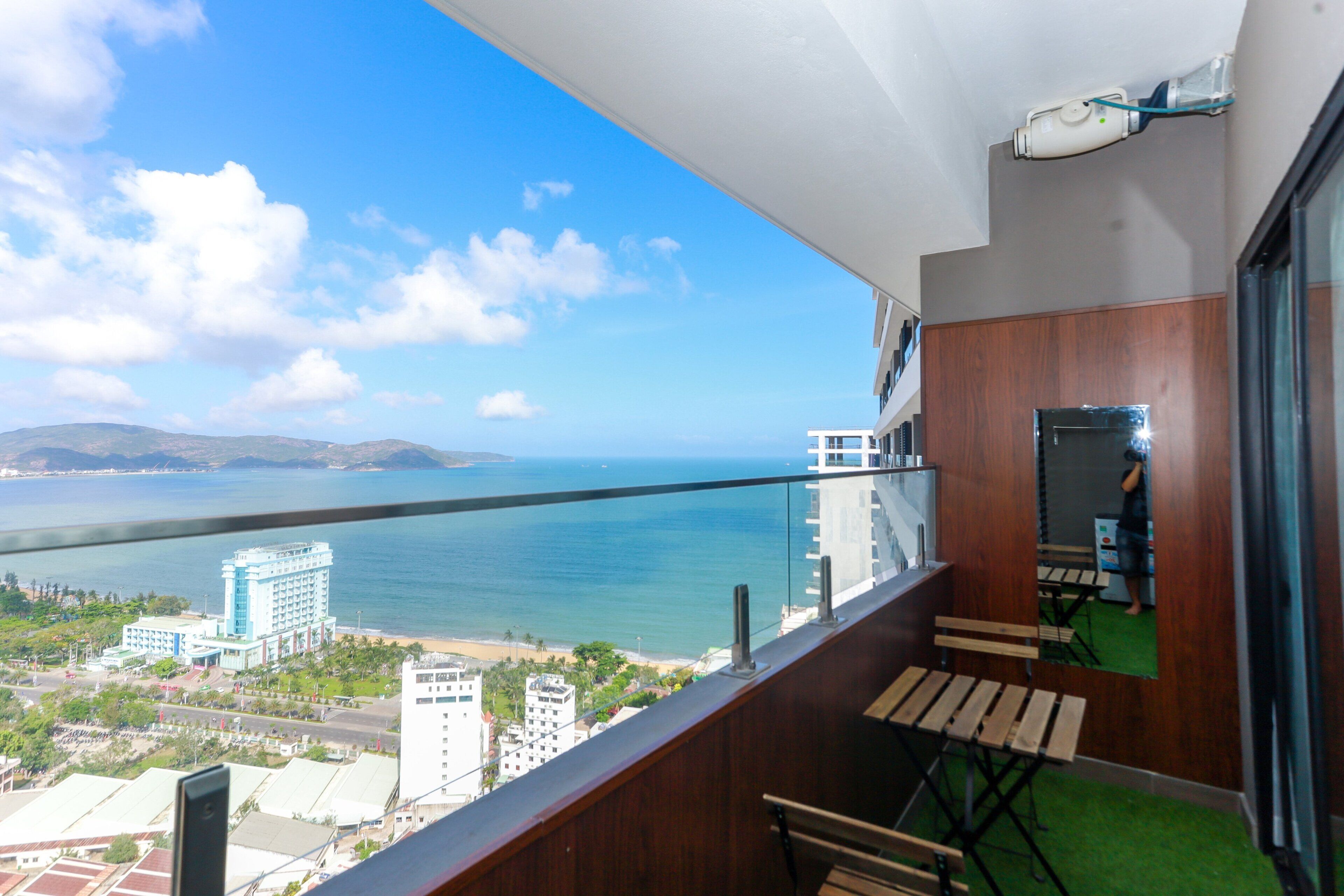 A balcony with a view of the sea and buildings.