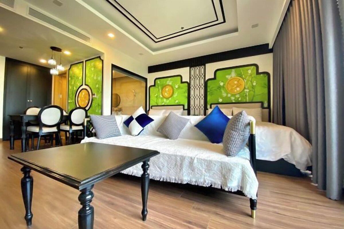 Una habitación de hotel moderna con una cama grande, una mesa de comedor y una zona de estar.