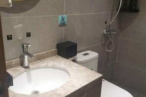 A bathroom with a sink, toilet, and shower.