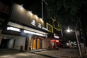 A building with a modern facade, large glass windows, and illuminated signage.