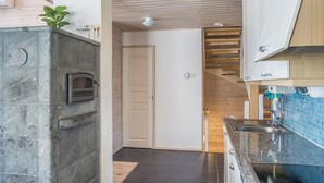 A modern kitchen with a built-in oven, a wooden staircase, and a blue tiled backsplash. - Pikku-pölly by Interhome (Sotkamo)