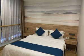 A hotel room with a bed, a nightstand with a phone, and a window with curtains. - Zizhongchuan East Business Hotel (Zizhong)