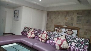 Una sala de estar moderna con un sofá modular, una mesa de centro de vidrio y una manta estampada.