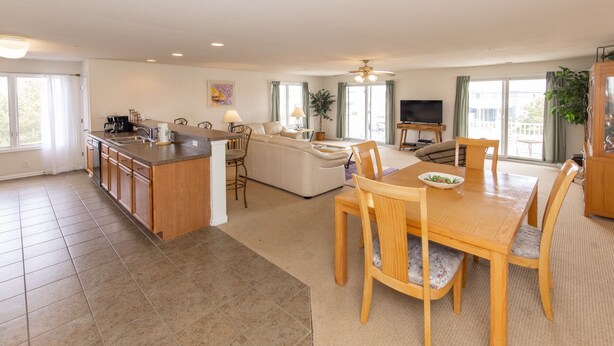 A spacious living area with a kitchen, dining table, and seating.