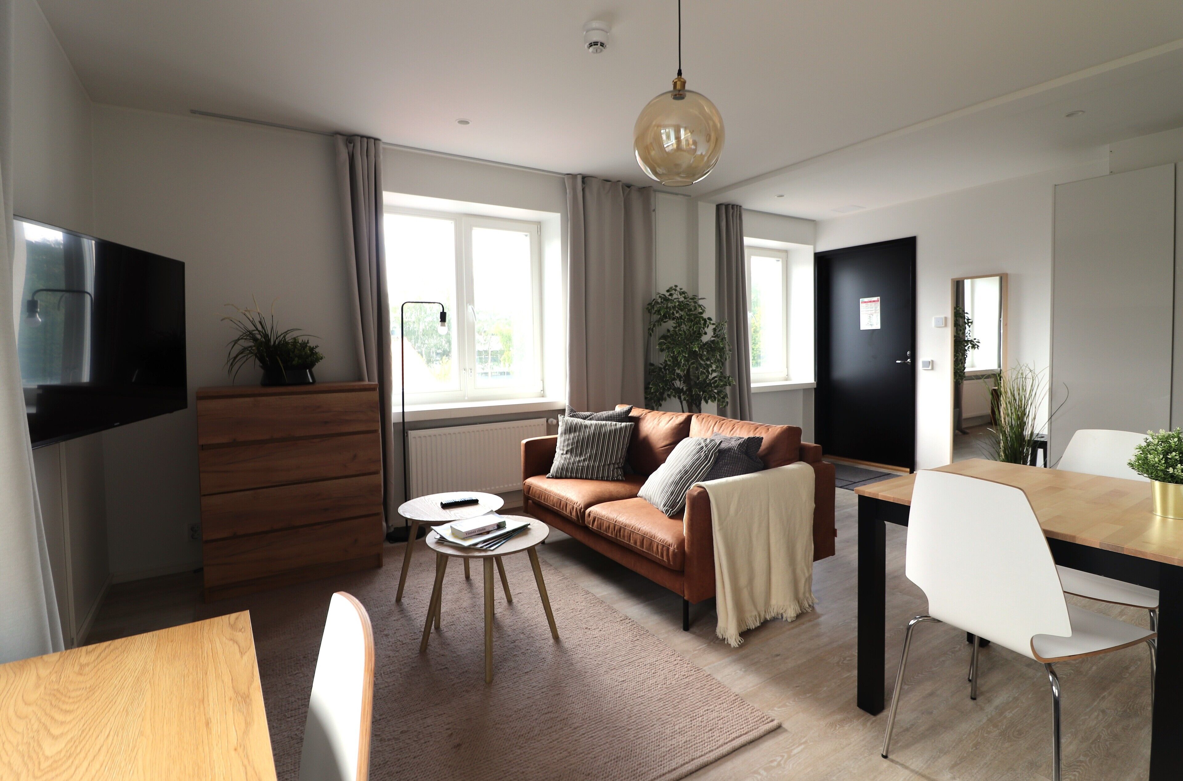 A modern living room with a sofa, coffee table, and dining table.