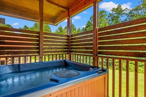 Ein Whirlpool mit Holzterrasse und Blick auf die umliegende Natur.