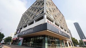 A modern building with a geometric facade and signage for a hotel. - Zexi Business Hotel (Taicang)