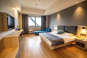 A modern hotel room with a large bed, a desk, a TV, and a window with curtains. - Zexi Business Hotel (Taicang)