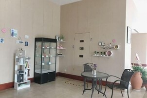 Una habitación con una mesa redonda, dos sillas, una estantería y un armario.