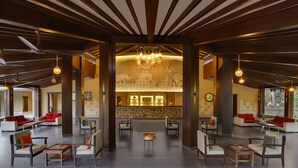 Un hall d’entrée spacieux, doté de sièges modernes, d’un espace d’accueil et d’un mur décoratif orné de motifs animaliers.