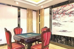 A room with a pool table, four chairs, and a large painting on the wall. - Hotel Intime Burqin (Burqin)