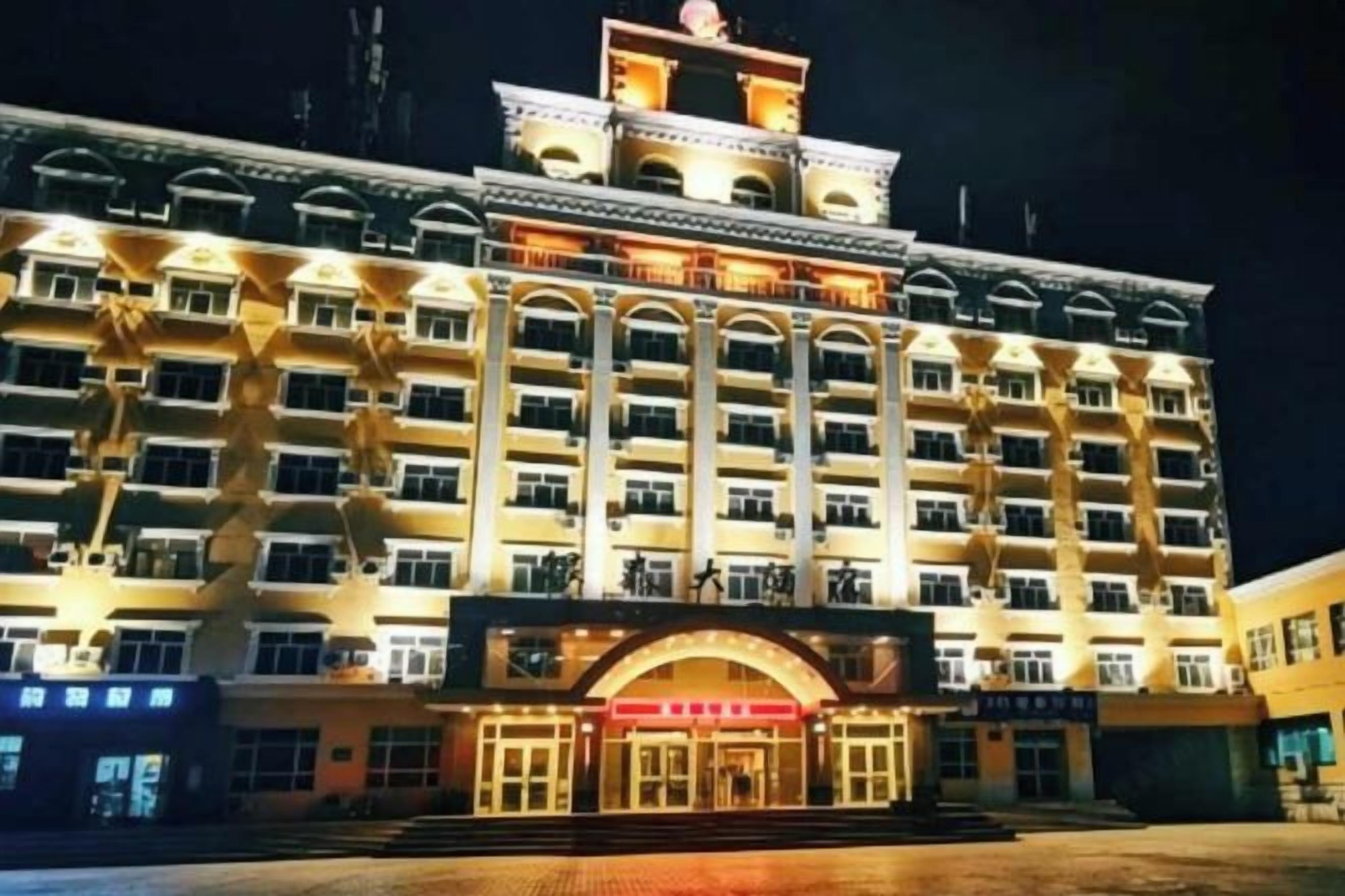 A multi-story hotel with a central entrance, multiple balconies, and a symmetrical facade.