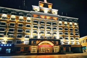 A multi-story hotel with a central entrance, multiple balconies, and a symmetrical facade. - Hotel Intime Burqin (Burqin)