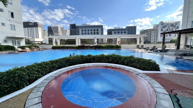 A rooftop swimming pool with a view of surrounding buildings. - IT Park Studio w/ washing machine (Cebu City)