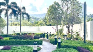 A landscaped garden with a curved pathway, trimmed hedges, and bollards. - IT Park Studio w/ washing machine (Cebu City)