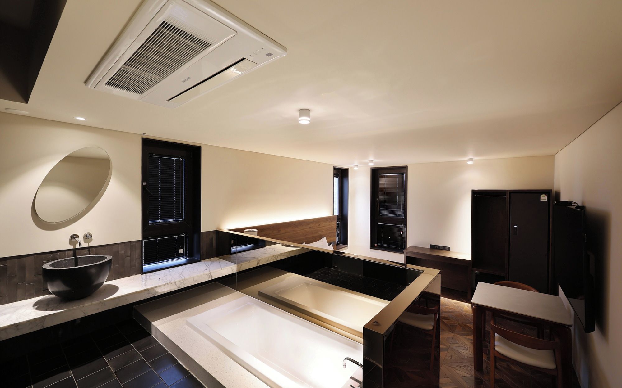 A modern bathroom with a large bathtub, a sink, and a mirror.