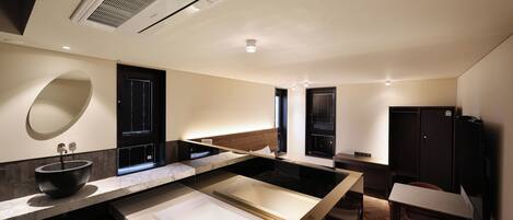 A modern bathroom with a large bathtub, a sink, and a mirror.