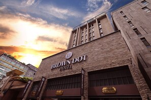 A hotel with a prominent sign reading 'BROWN DOT HOTEL,' featuring a brick facade and large windows. - Brown Dot Hotel Dongtan (Hwaseong)