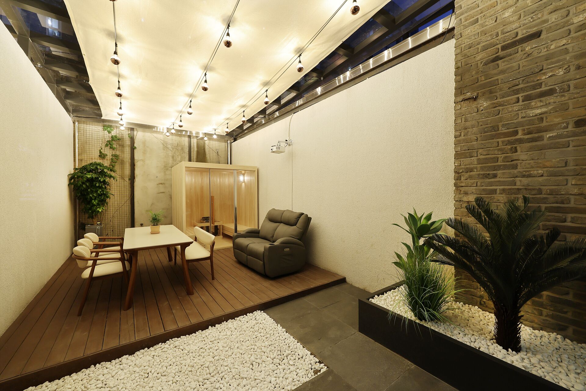 A modern interior with a wooden table and chairs, a cushioned seating area, and a brick wall.