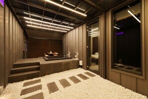 Un baño moderno con un espejo grande, un lavamanos y una ventana.